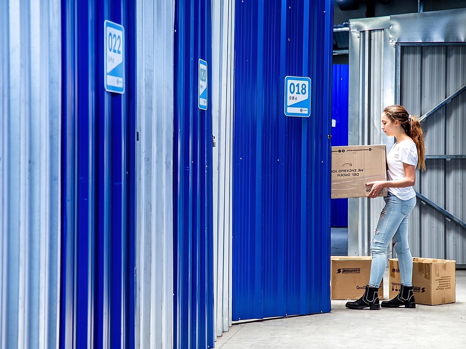 Una clienta lleva una caja por el pasillo de la sucursal de Almagro, entre puertas azules numeradas